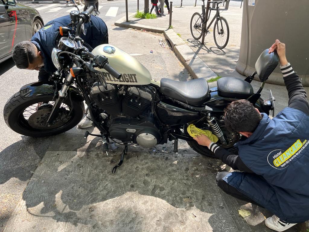 Deux laveurs Mister Clean Cars nettoient une Harley-Davidson Sportster dans la rue